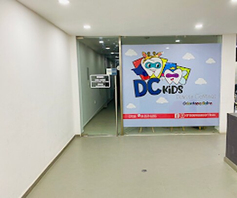 Entrada de DC Kids Odontopediatra, con el logo en el cristal, en Plaza Vía 29